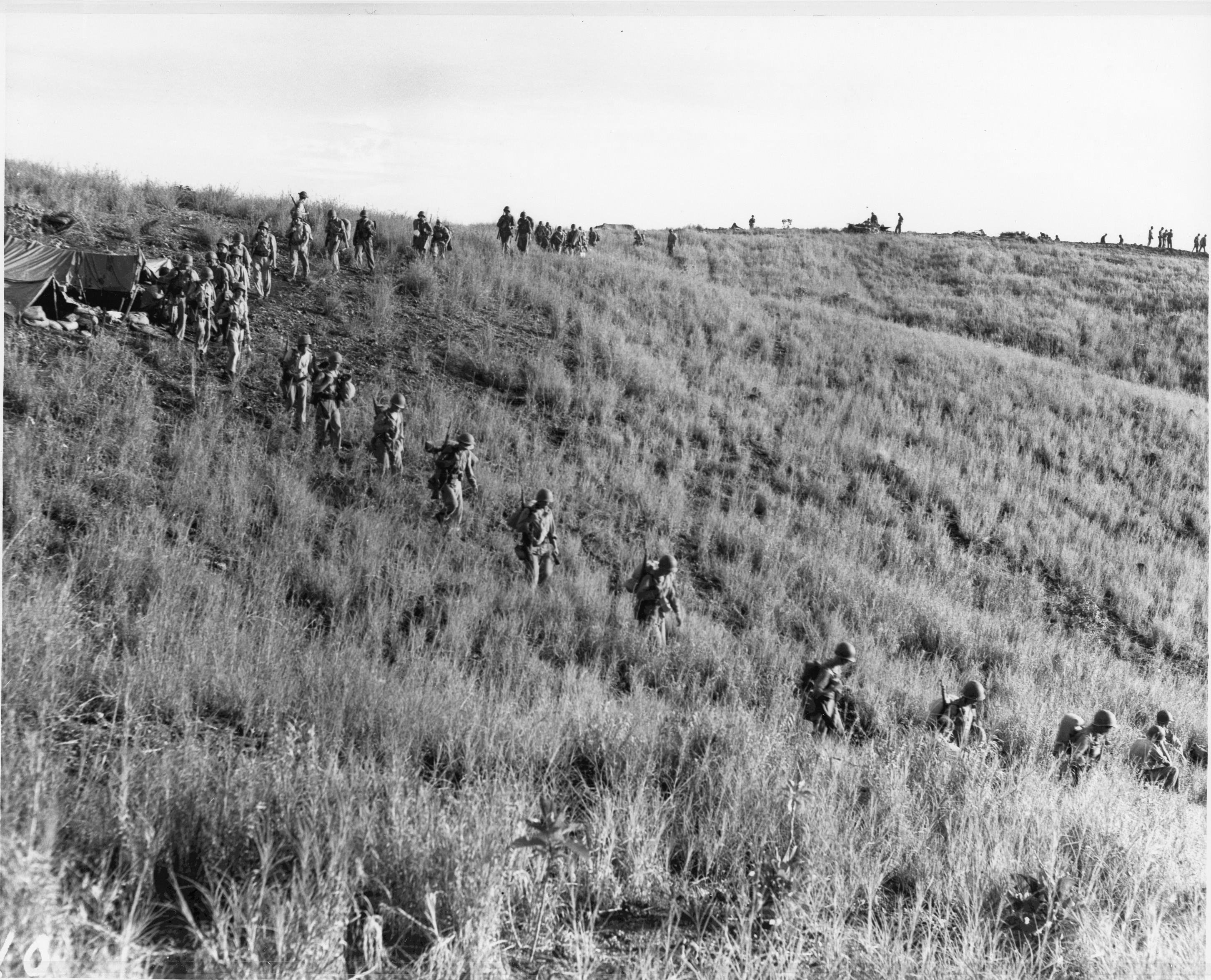 US Marines moving in a column over a hill on Guadalcanal, Solomon Islands, 10 Jan 1943