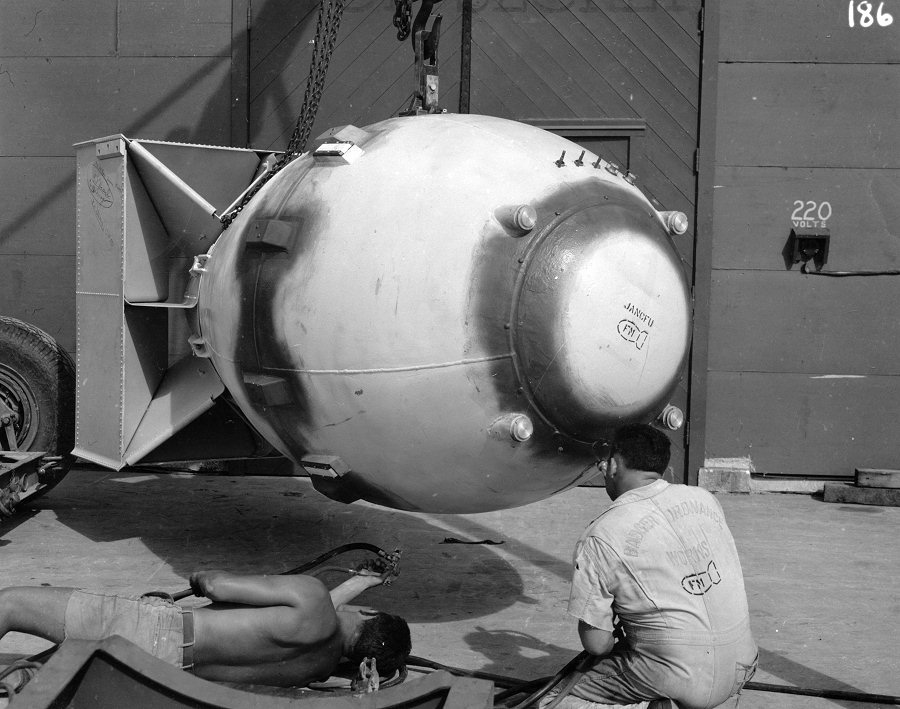 Technician spraying 'Fat Man' bomb with plastic paint in front of Assembly Building Number 2, Tinian, Mariana Islands, Aug 1945, photo 2 of 4