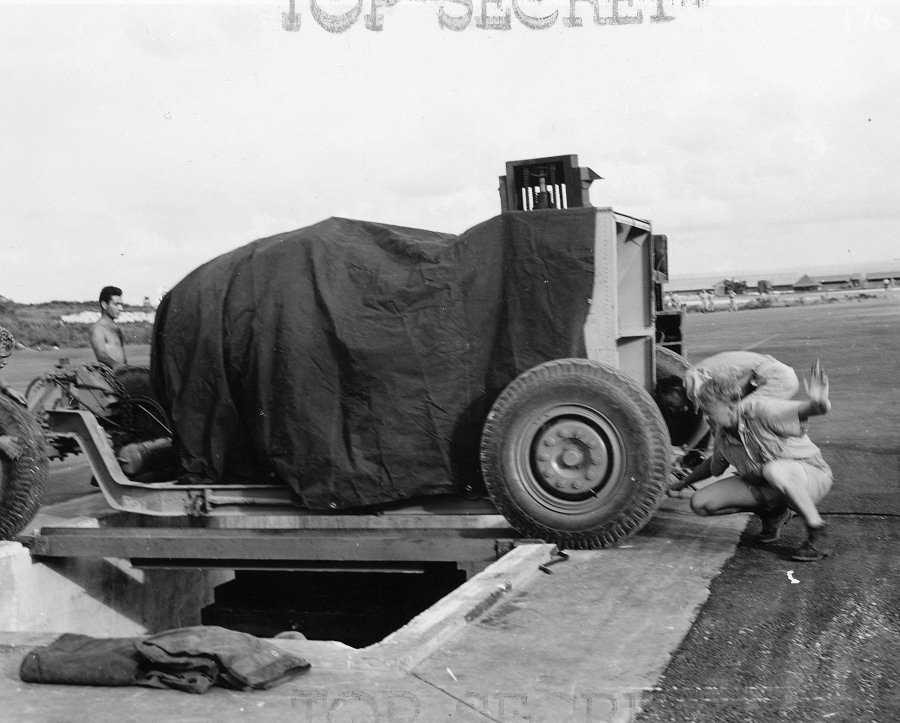 Lowering 'Fat Man' bomb into a bomb pit at the airfield on Tinian, Mariana Islands, Aug 1945, photo 1 of 5