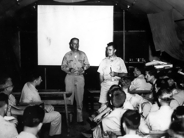 Captain William Sterling Parsons and Colonel Paul Tibbets, Jr. briefed the crew of B-29 Superfortress 'Enola Gay' before the Hiroshima attack, 5 Aug 1945