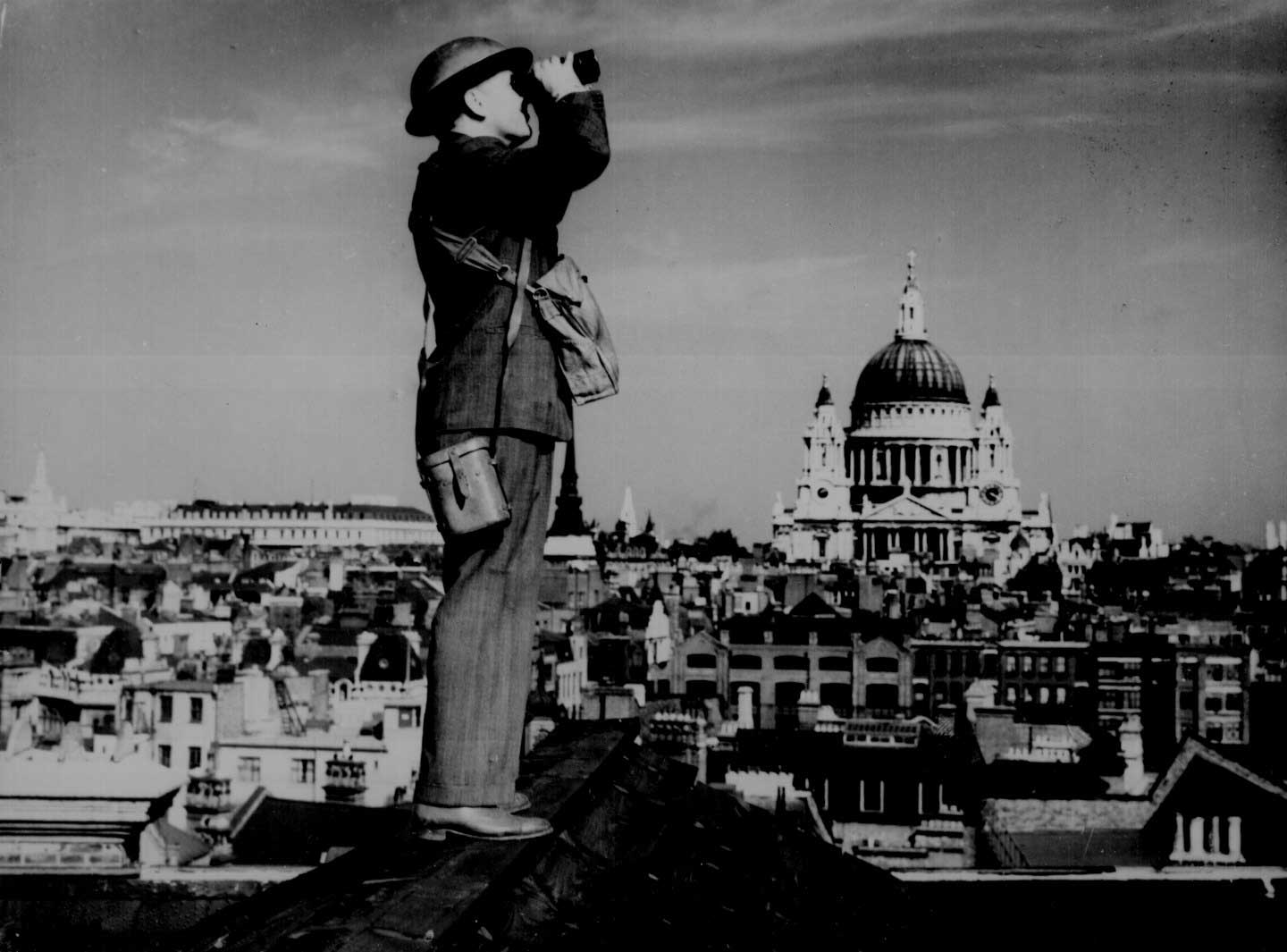 An aircraft spotter atop a London building, St. Paul's Cathedral in background, early 1940s