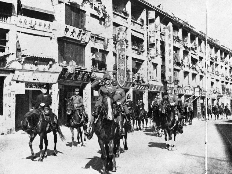 Takashi Sakai and Masaichi Niimi leading Japanese troops on a march on Queen's Road, Hong Kong, 26 Dec 1941, photo 2 of 2
