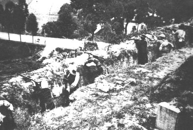 Dongjiang Column communist Chinese guerrilla fighters firing from a ditch, Hong Kong or Guangdong Province in China, circa 1942-1945