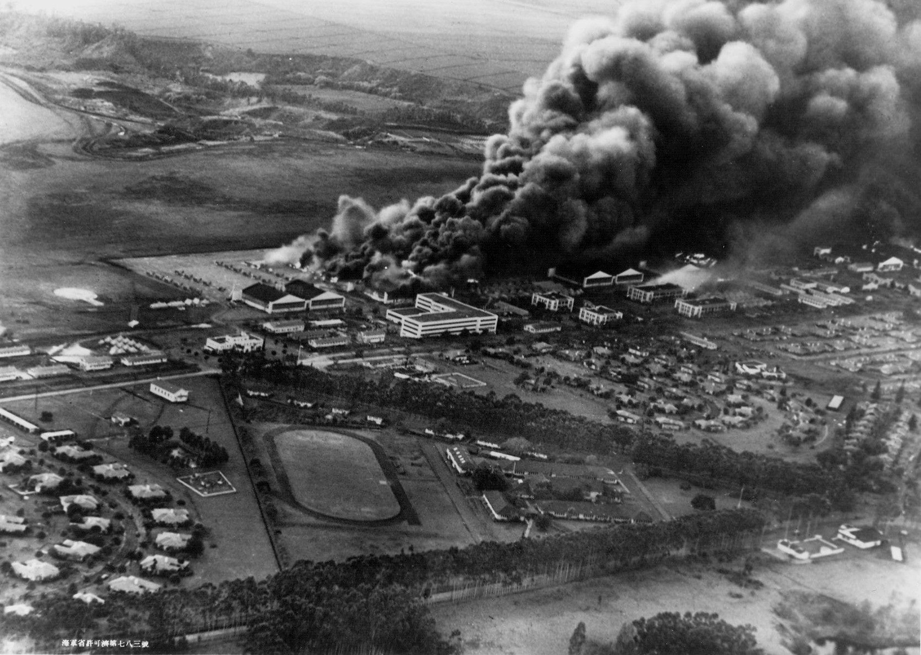 P-40 fighters and hangars burning at Wheeler Field, US Territory of Hawaii, 7 Dec 1941; photo taken from a Japanese aircraft