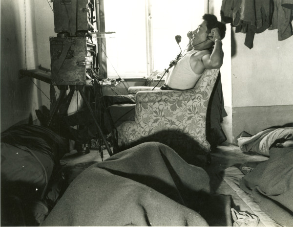 Japanese-American switch operator of US 442nd Regimental Combat Team at a foward command post, Castellina Sector, Italy, 12 Jul 1944; note other switch operators sleeping in same room
