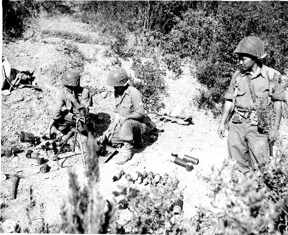 Japanese-American mortar crew of 100th Infantry Battalion, US 442nd Regimental Combat Team firing into suspected German sniper positions, Montenero area, Italy, 7 Aug 1944, photo 2 of 2