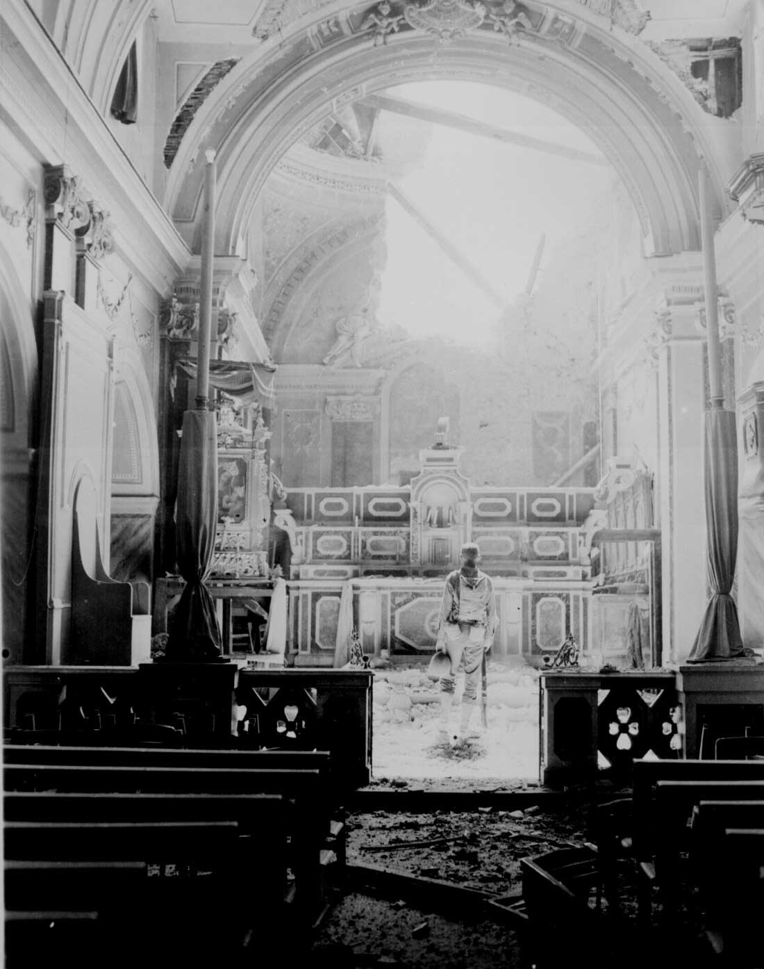 Private Paul Oglesby of US 30th Infantry Regiment standing before an altar in a damaged Catholic Church at Acerno, Italy, 23 Sep 1943