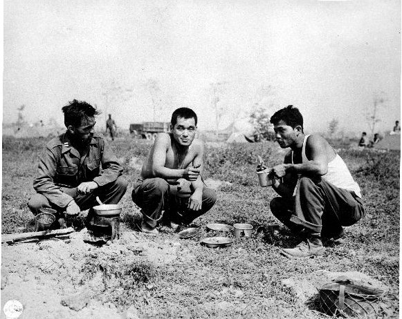 Japanese-American troops of US 442nd Regimental Combat Team eating a meal in the field, Italy, date unknown