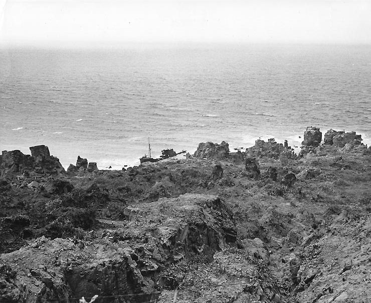 A Japanese patrol vessel wrecked on the rocky coast of northern Iwo Jima, 21 Apr 1945