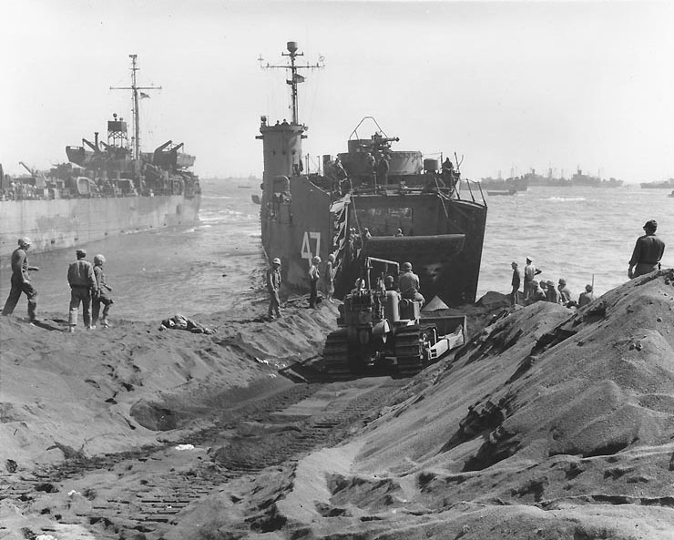 A bulldozer preparing a roadway as LSM-47 opened her cargo bay doors, Green Beach, Iwo Jima, Japan, circa 25 Feb 1945