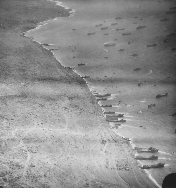 Aerial photograph of Iwo Jima's east landing beaches as LSTs, LSMs, and LCTs unloaded supplies, circa late Feb 1945