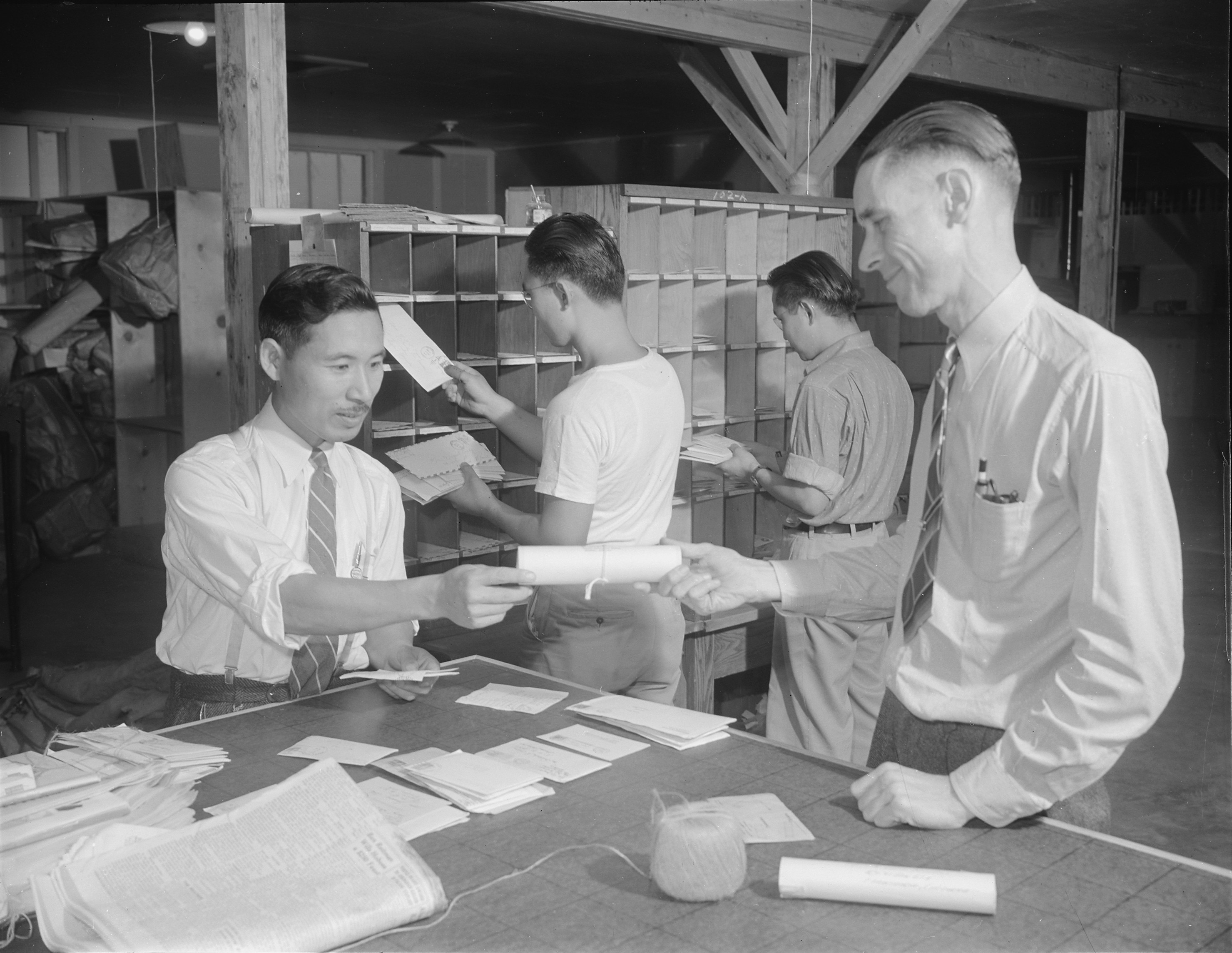Postmaster Fred Paris with workers at the Jerome War Relocation Center post office, Arkansas, United States, 20 Nov 1942
