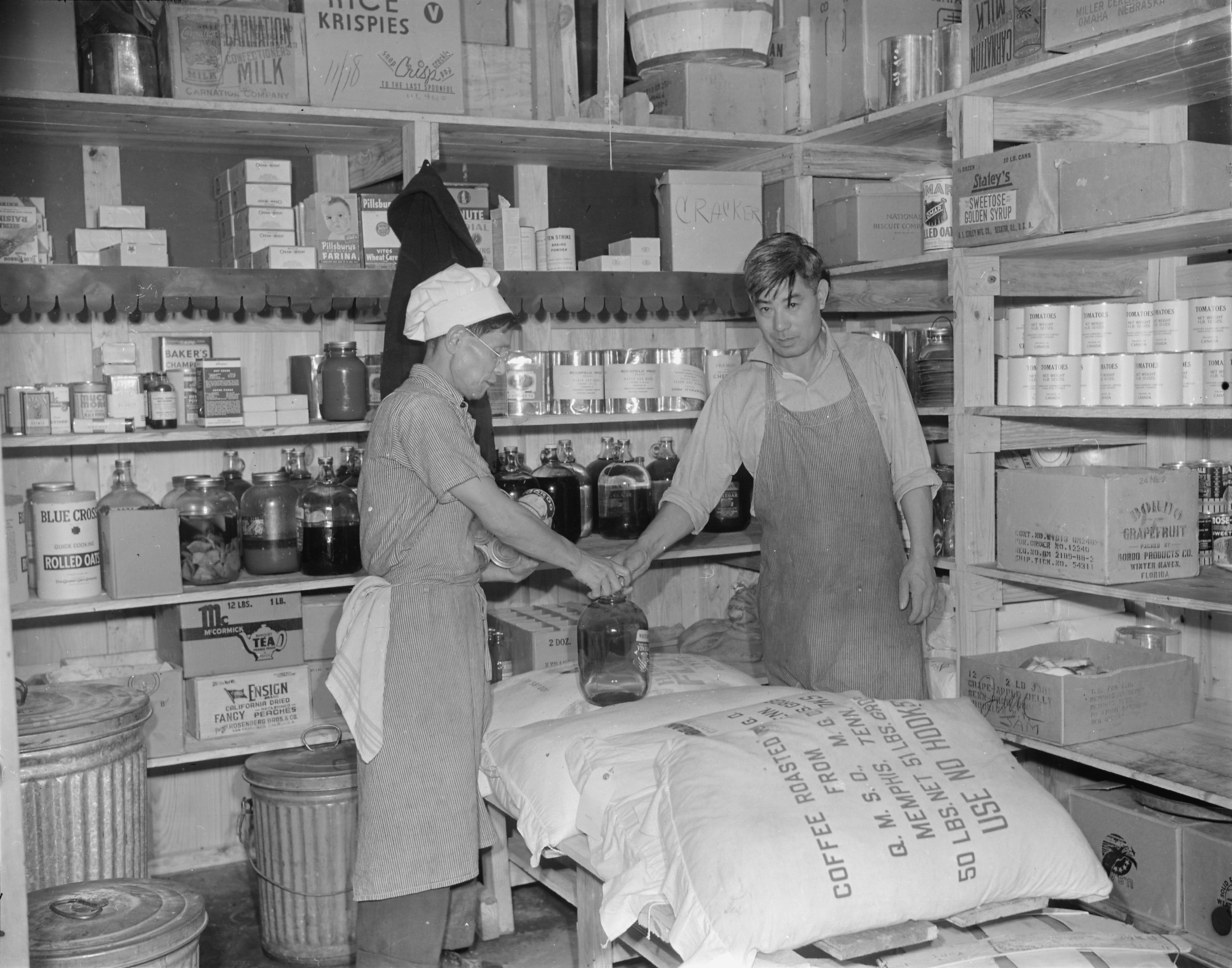 Chief cook Hamazaki and storekeeper Jimmy Saito at the storeroom of Mess Hall 7 of Jerome War Relocation Center, Arkansas, United States, 18 Nov 1942