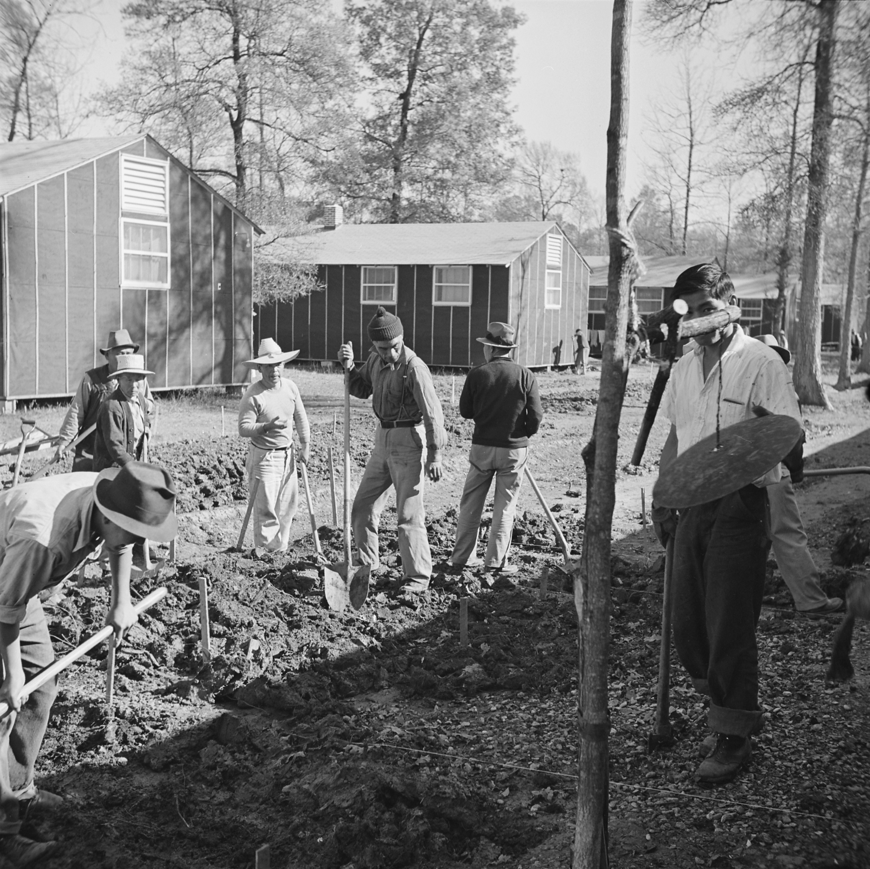 Men digging drainage ditches by the mess hall of Block 7 of Jerome War Relocation Center, Arkansas, United States, 16 Nov 1942, photo 1 of 2