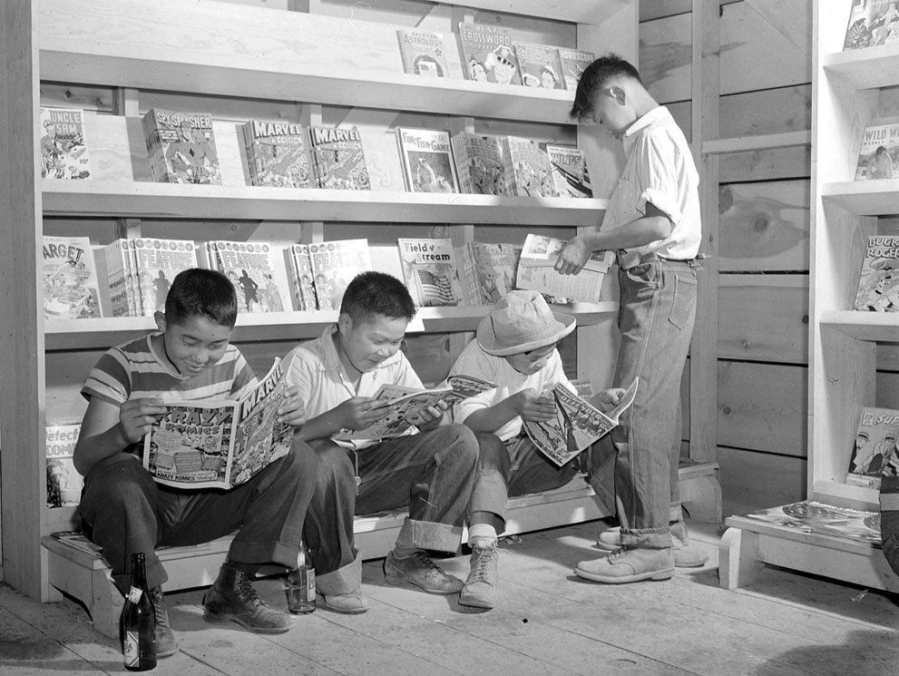 Japanese-American boys reading comic books in Tule Lake Relocation Center, Newell, California, United States, 1 Jul 1942