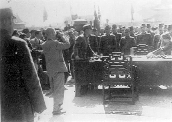 Surrendered Japanese officers' swords, table, and chairs being removed by Chinese soldiers for the nearby National History Museum, Forbidden City, Beiping, China, 10 Oct 1945
