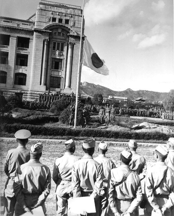 Japanese flag being lowered during the surrender ceremony at the General Government Building, Seoul, Korea, 9 Sep 1945