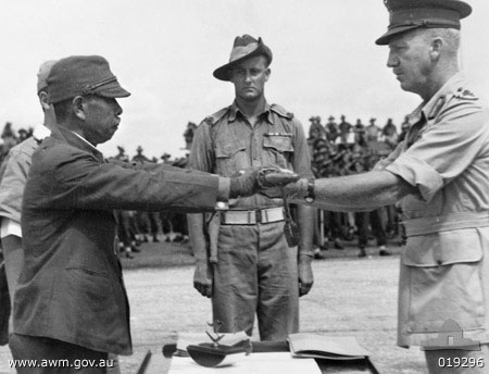 Lieutenant General Hatazo Adachi symbolically surrendered his sword to Australian Major General H. C. H. Robertson at Wom Airstrip, New Guinea, 13 Sep 1945