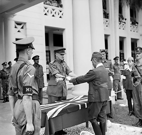 Lieutenant General F. W. Messervy of Malaya Command receiving the sword of General Itagaki of Japanese 7th Area Army at a formal ceremony of surrender, Victoria Institution, Kuala Lumpur, Malaya, 22 Feb 1946