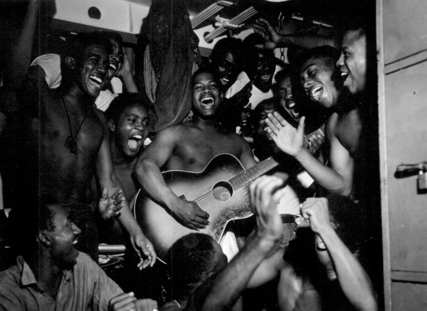 US Navy African-American enlisted sailors aboard USS Ticonderoga celebrating upon hearing the news of Japanese surrender, 14 Aug 1945