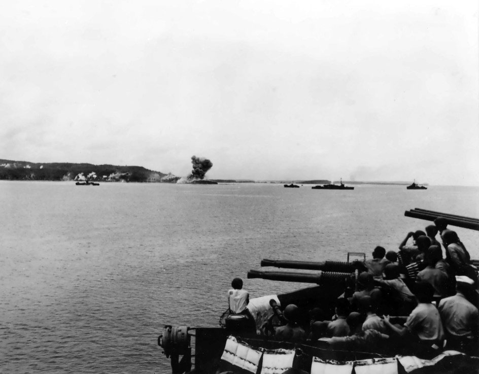 40mm gun crew of an unidentified American cruiser watched as lighter vessels shelled a Japanese storage dump (note smoke in center), Asan Beachhead, Guam, Mariana Islands, 21 Jul 1944