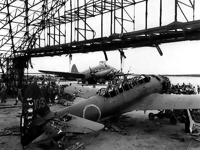 Wrecked C6N-1 aircraft of Japanese Navy 121st Kokutai in a hangar, Ushi Point Airfield, Tinian, Mariana Islands, 30 Jul 1944. Note the Marine Corps Curtiss R5C-1 Commando in the background.
