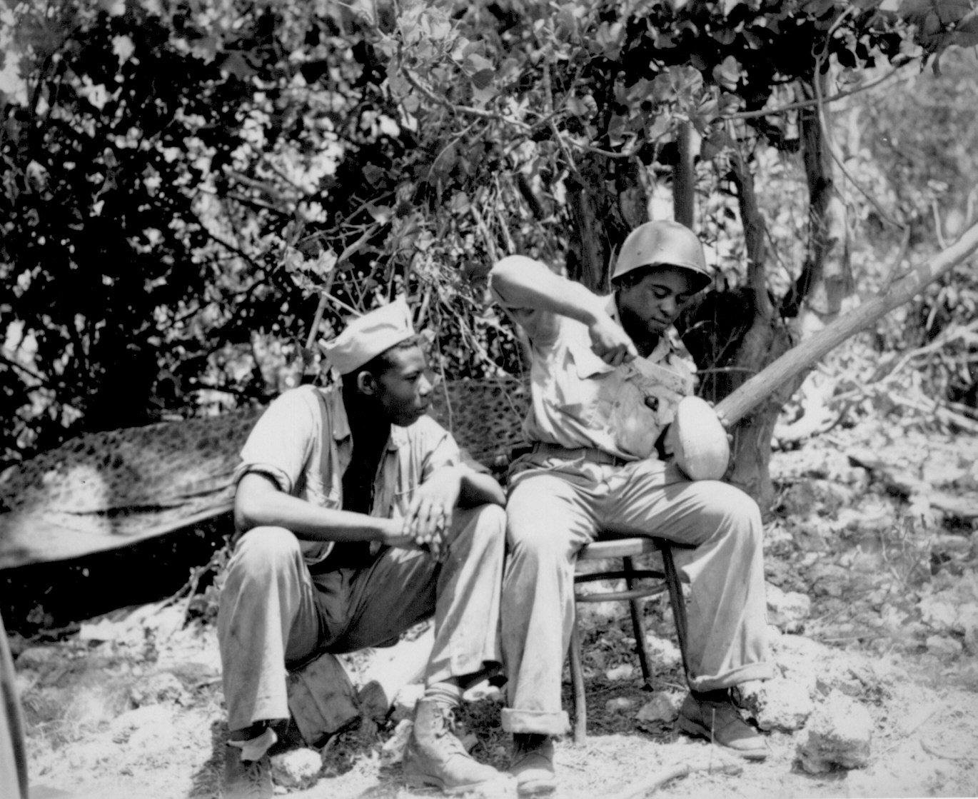 African-American US Marines Sergeant F. Smit and Corporal S. Brown opening a coconut, Saipan, Mariana Islands, Jun 1944