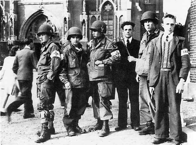 Troops of US 101st Airborne Division with members of Dutch resistance at the Sint-Lambertuskerk cathedral, Veghel, Netherlands, Sep 1944