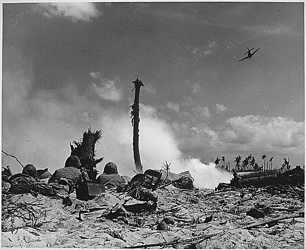 A group of US Marines observed as an aircraft above strafed Japanese positions ahead, Eniwetok, Marshall Islands, circa 18-21 Feb 1944