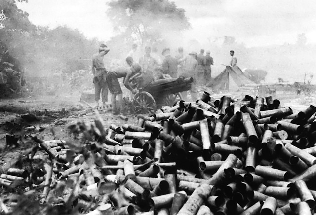 Spent 75-mm howitzer shells piling up outside the besieged city Myitkyina, Burma, mid-1944; note M1 carriage