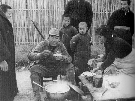 Japanese soldier dining among Chinese civilians, Nanjing, China, 15 Dec 1937