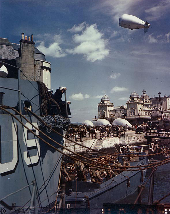 US Army soldiers boarding landing craft at Weymouth, Dorset, England, United Kingdom, while preparing for the Normandy operation, 1 May 1944; note barrage balloons aloft and on the ground