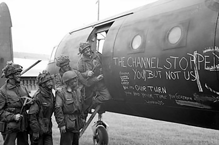 British airborne troops admiring the graffiti chalked on the side of their Horsa Mk I glider, 6 Jun 1944