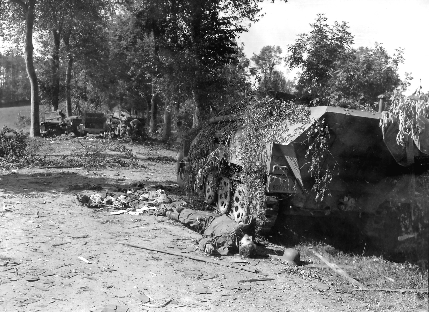 A German mechanized column devastated by British aircraft, near Mortain, France, 7 Aug 1944; note dead German soldier near wrecked SdKfz. 251 halftrack vehicle