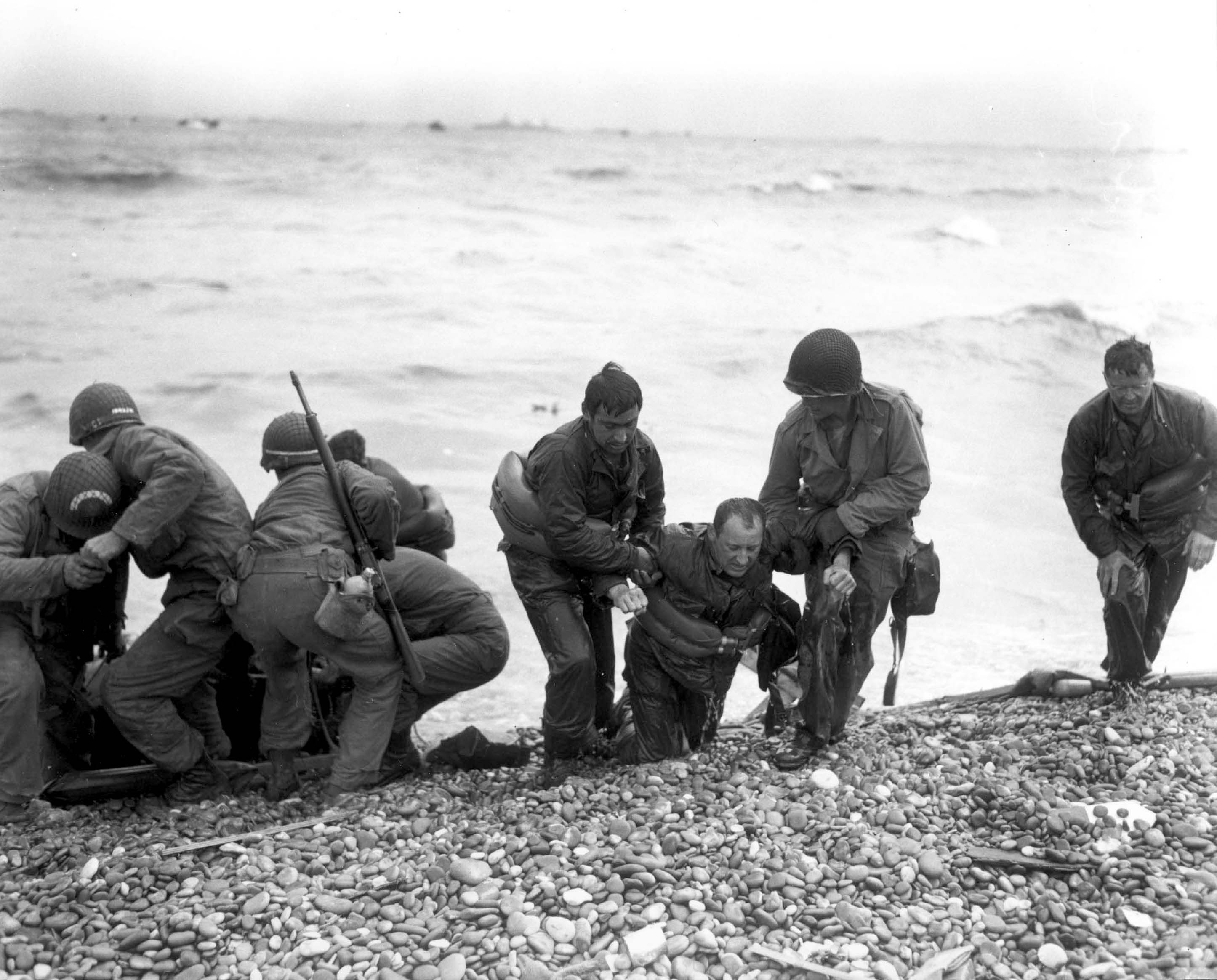 Members of an American landing party helped those whose landing craft were sunk, Omaha Beach Normandy, 6 Jun 1944
