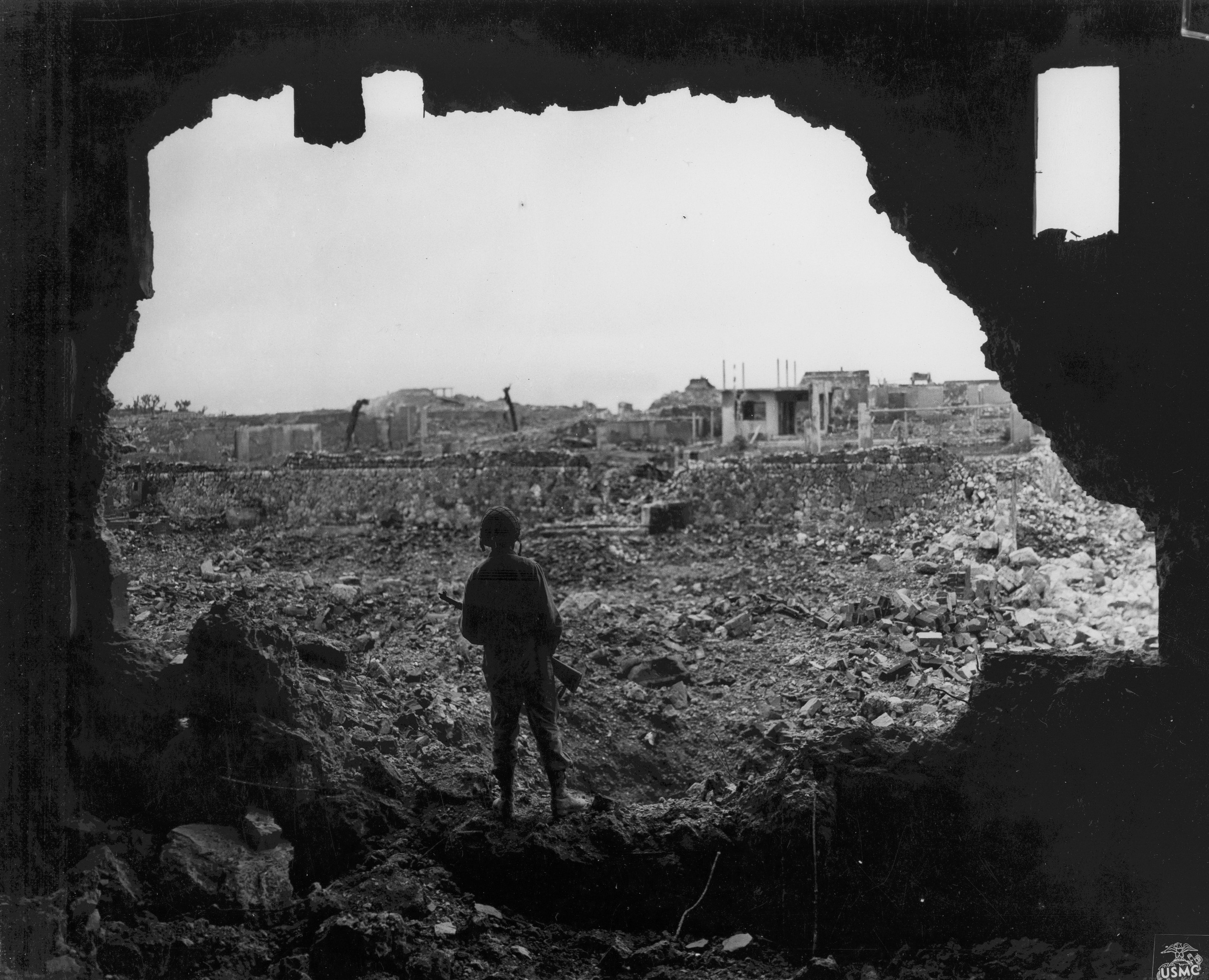 A US Marine observing ruined buildings in Naha, Okinawa, Japan, 13 Jun 1945