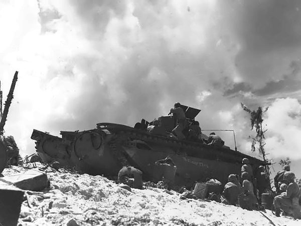 Using an Amtrac as shelter, American Marines fought on the beaches of Peleliu, Palau Islands, 15 Sep 1944