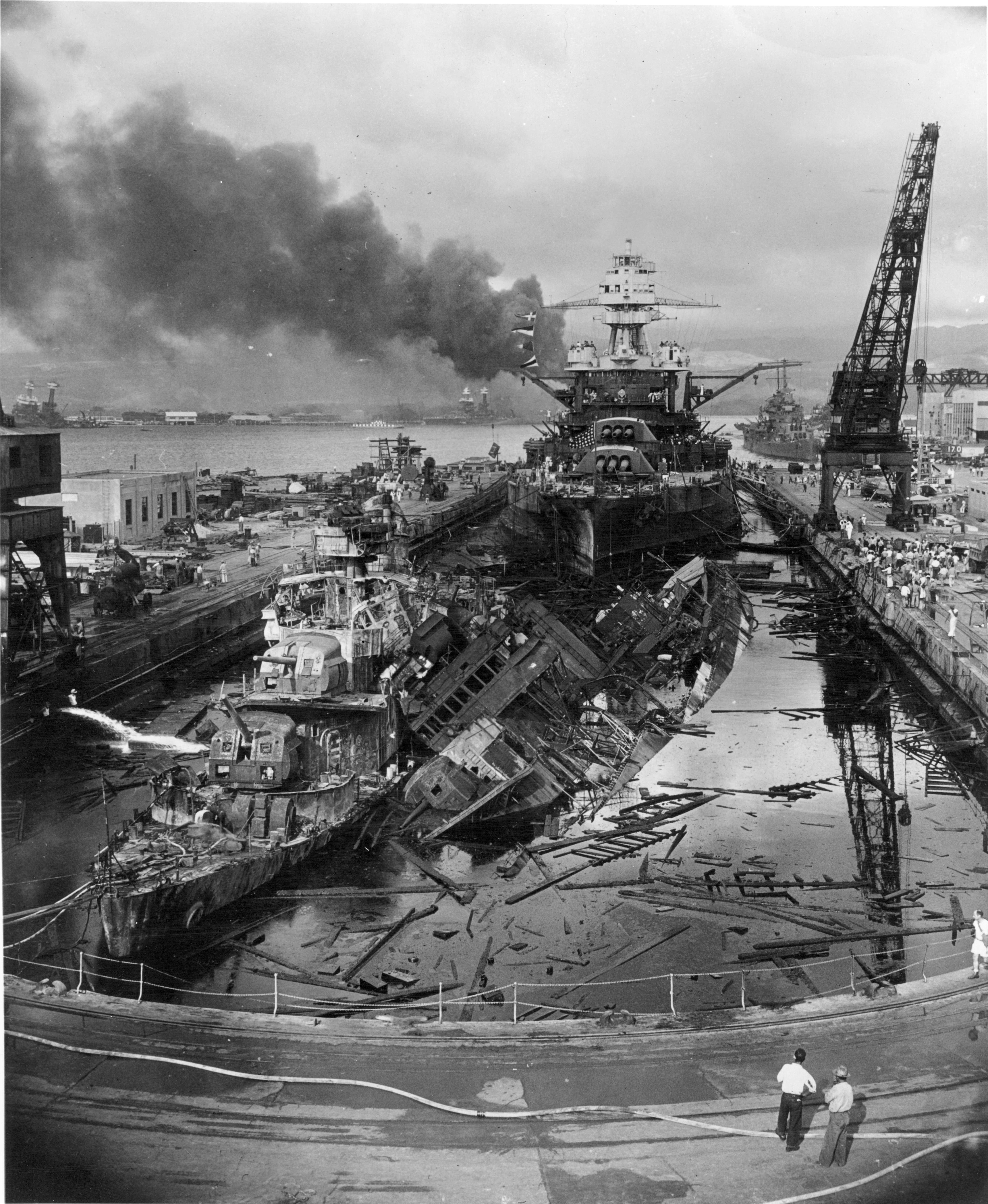 Wrecks of destroyers Downes and Cassin in Drydock One at Pearl Harbor Navy Yard, 7 Dec 1941 about 1400, photo 1 of 5; note Pennsylvania in the rear, Helena in distance, Oklahoma and Maryland in far background