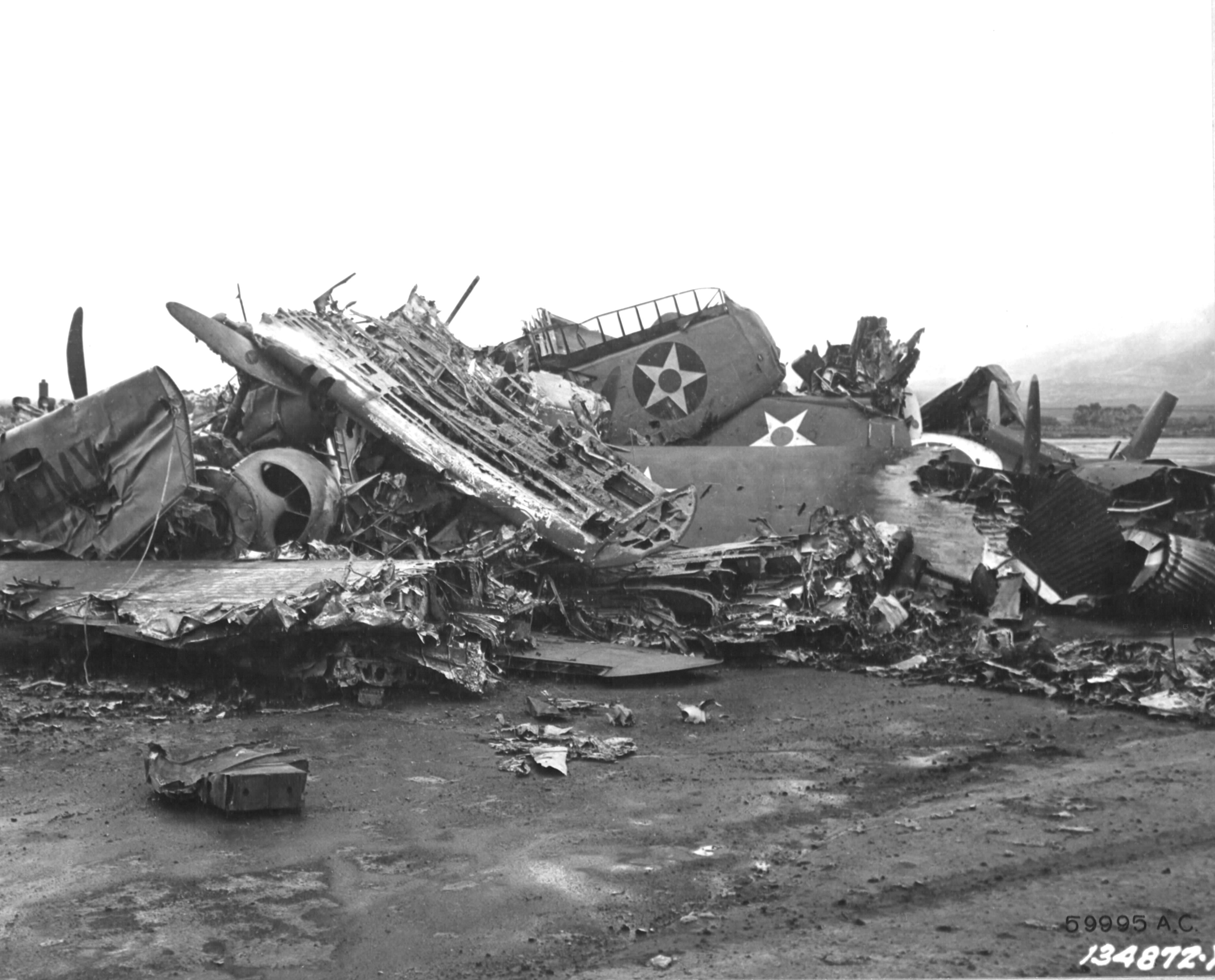 Destroyed US Army aircraft at Wheeler Field, Oahu, during post-Pearl Harbor raid clean up, Dec 1941; note P-40 parts in the pile