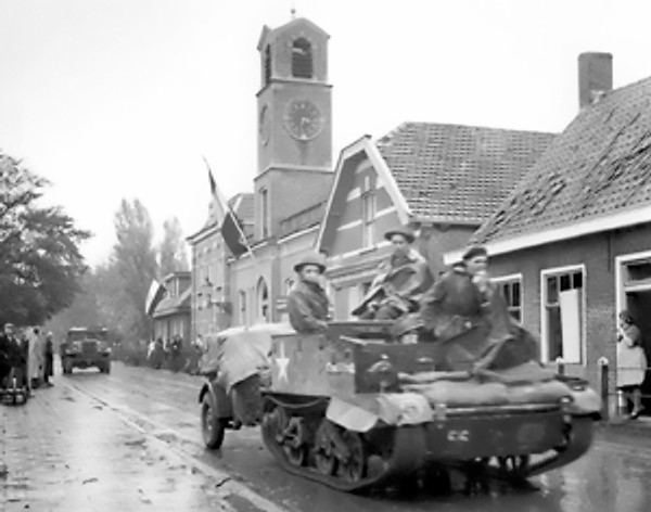 Canadian Royal Hamilton Light Infantry carriers moving through the Dutch village of Krabbendijke on the Beveland Causeway, 27 Oct 1944