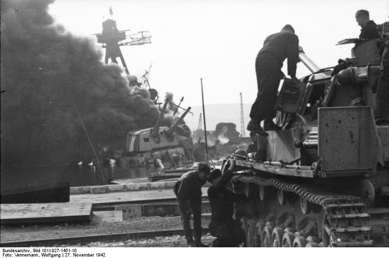 German Panzer IV tank and crew at Toulon harbor, France, 27 Nov 1942; note French cruiser Colbert burning in background