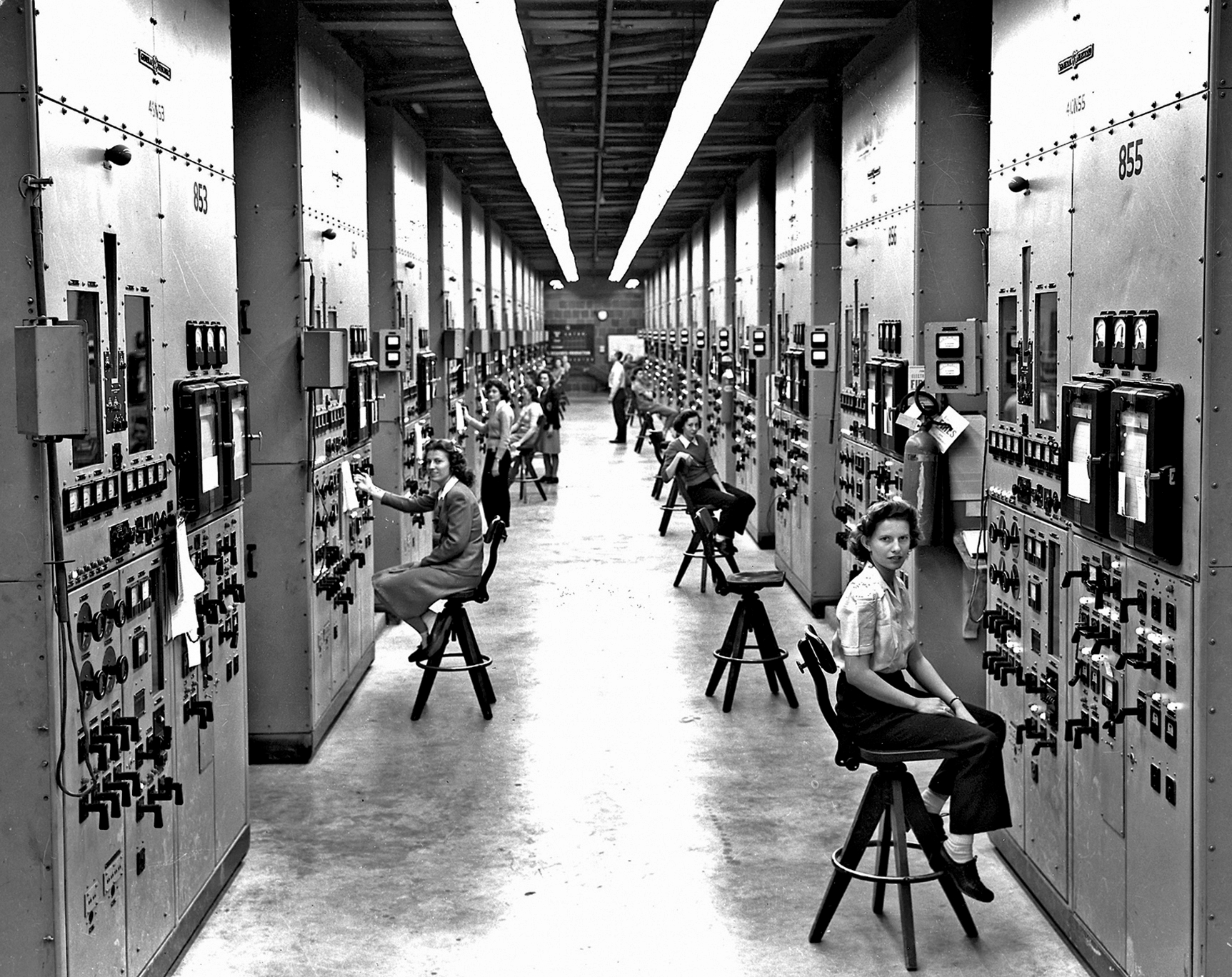 Control panels and operators for calutrons at the Y-12 Plant in Oak Ridge, Tennessee, United States; the woman closest to the camera was identified as Gladys Owens