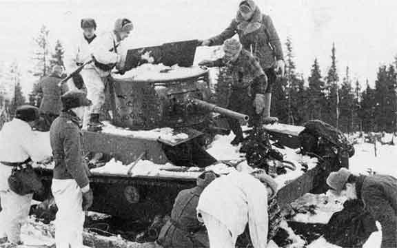 Finnish troops inspecting a wrecked Soviet T-26 tank after the Battle of Raate Road, Finland, Jan 1940