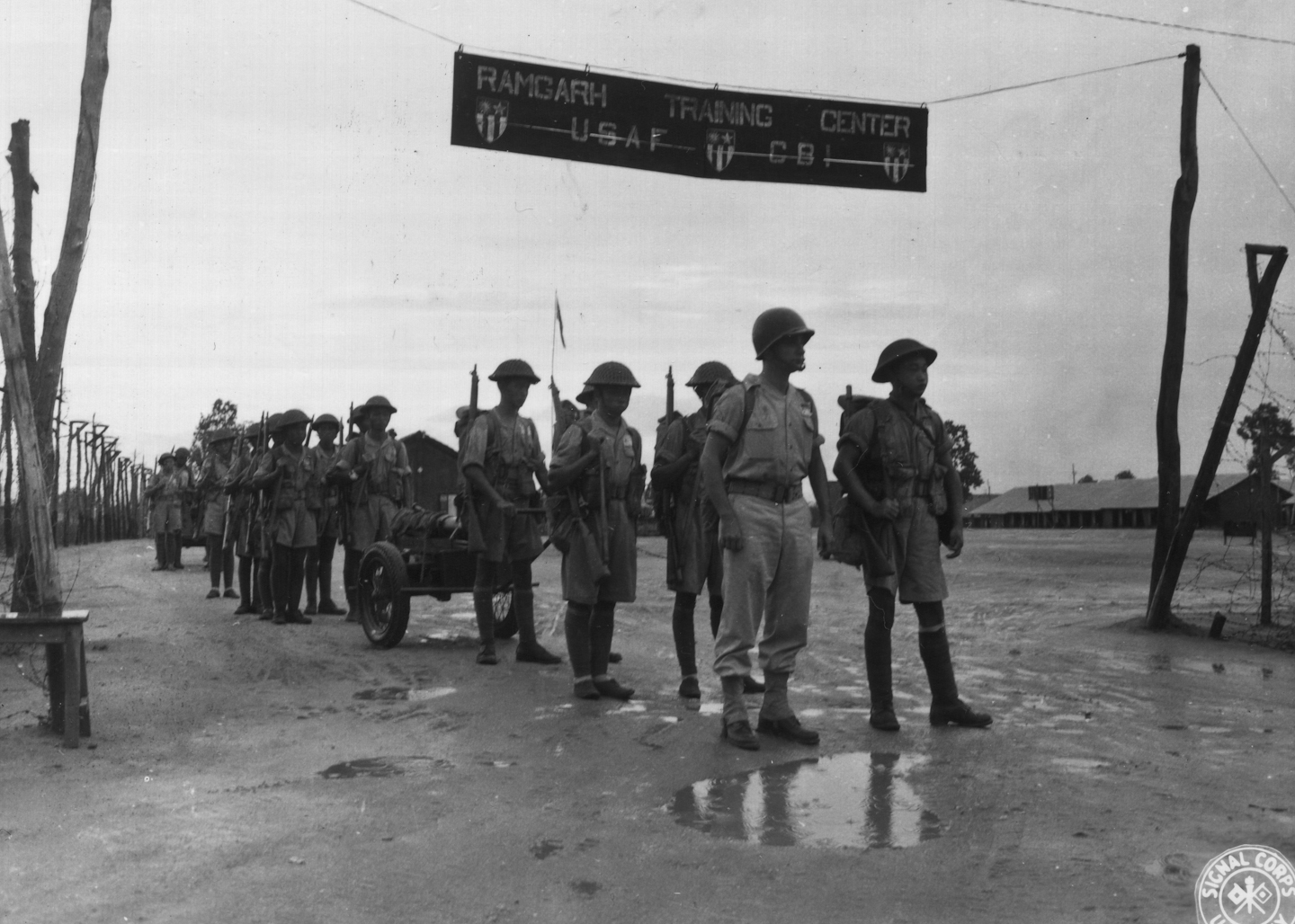 Chinese mortar regiment going through entrance to Ramgarh Training Center, India, Jun 1944; note US instructor at the head of column