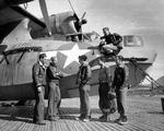 Flight crews gather around a PBY-5A Catalina patrol plane on a Marsden Mat seaplane ramp in the Aleutians, 1944-45. Note oil splatters on the hull from the notoriously leaky radial engines.