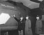 Col Leon W Johnson points to scoreboard of B-24 Liberator “Victory Ship” as LGen Jacob L Devers and LGen Ira C Eaker look on, RAF Shipdham, Norfolk, England, UK, Nov 22 1943. The horizontal bomb represents the low level attack on Ploesti, Aug 1 1943