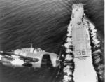 TBM-3E Avenger circles over the flight deck of USS Antietam off Hawaii, 1945. Note F4U Corsairs, SB2C Helldivers, and F6F Hellcat on the flight deck.