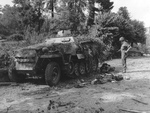 A soldier of the US Army looks at a German half-track camouflaged with branches near Le Neufbourg, France, Aug 12 1944. The half-track SdKfz 251 Ausf D, SS 926256 is from the 1.SS-Panzer-Division Leibstandarte Adolf Hitler. Note the soldiers M3 Grease Gun