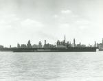 Training aircraft carrier USS Wolverine underway on Lake Michigan with the Chicago skyline behind, 22 Mar 1943.