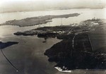 Entrance to Pearl Harbor, Hawaii looking north.  Bishop Point in the Main Channel is at the bottom, with the Coal Docks at the base of the left radio tower, and the shipyard at right, 1919-1921